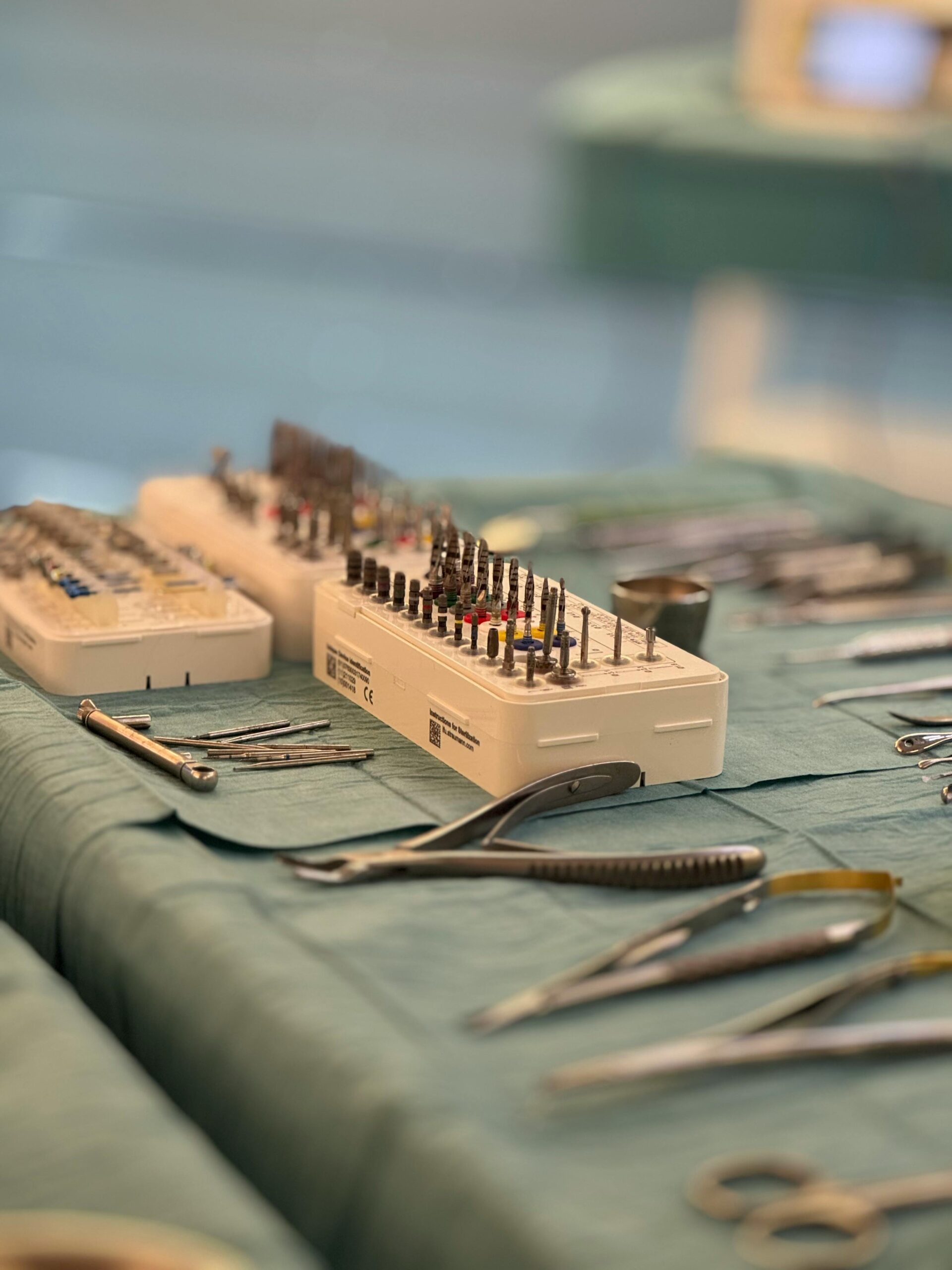 Surgical tools and dental instruments organized on a sterile table in an operating room.